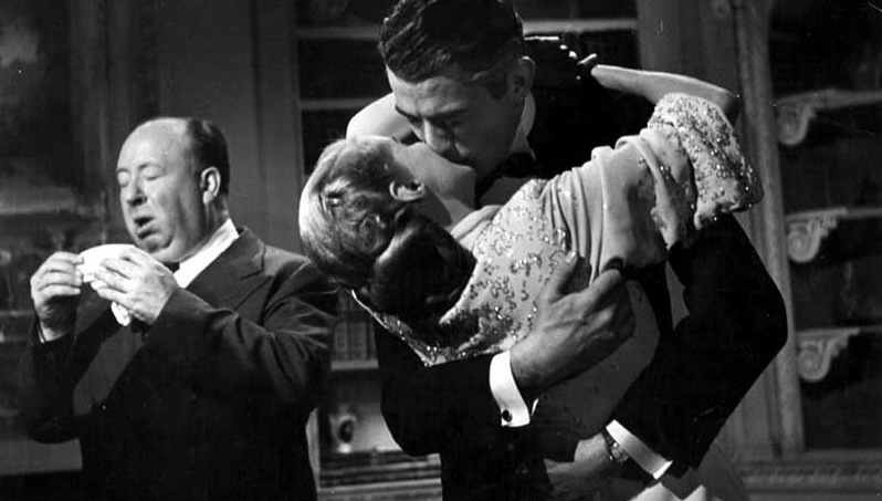 Alfred Hitchcock sneezing while Ann Todd and Gregory Peck kiss on the set of The Paradine Case